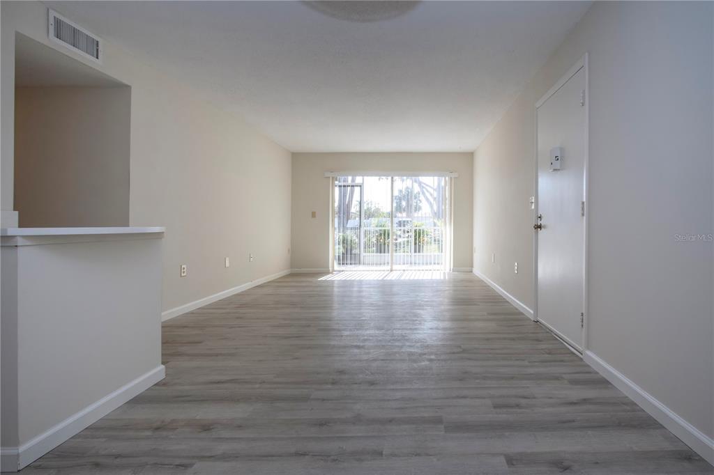 3259 South Beneva Road, Unit 102 Sarasota, FL 34232 - Photo 4 of 38 a view of an empty room with wooden floor and a window