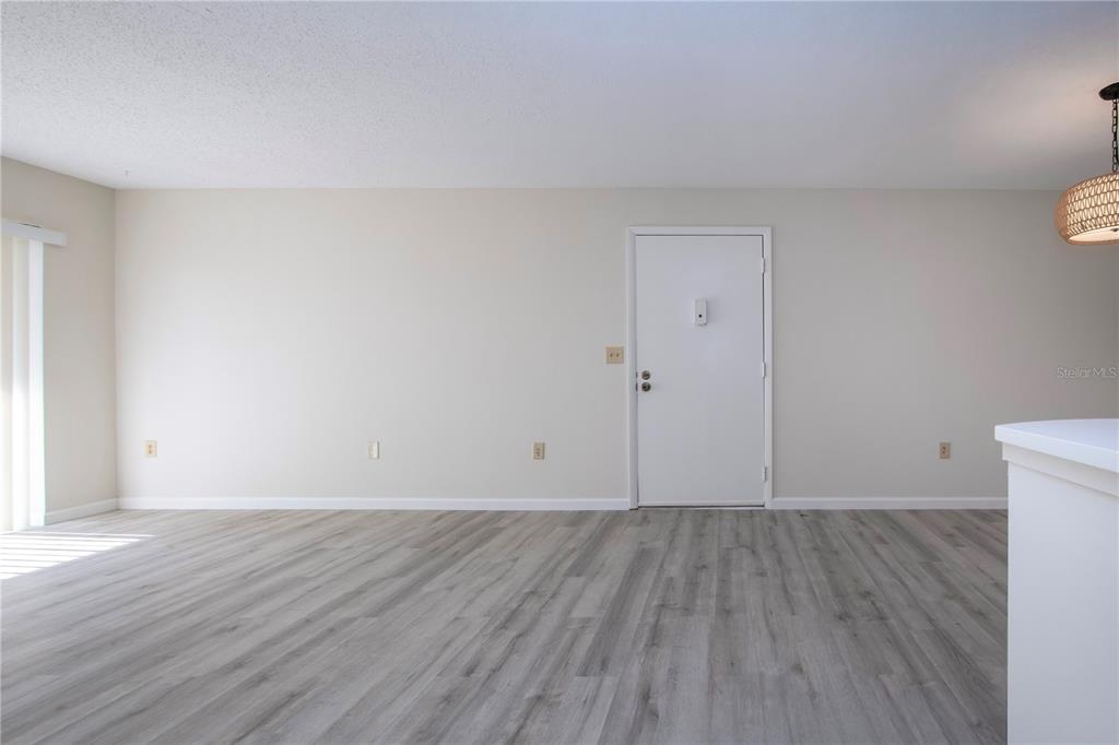 3259 South Beneva Road, Unit 102 Sarasota, FL 34232 - Photo 5 of 38 a view of an empty room with wooden floor