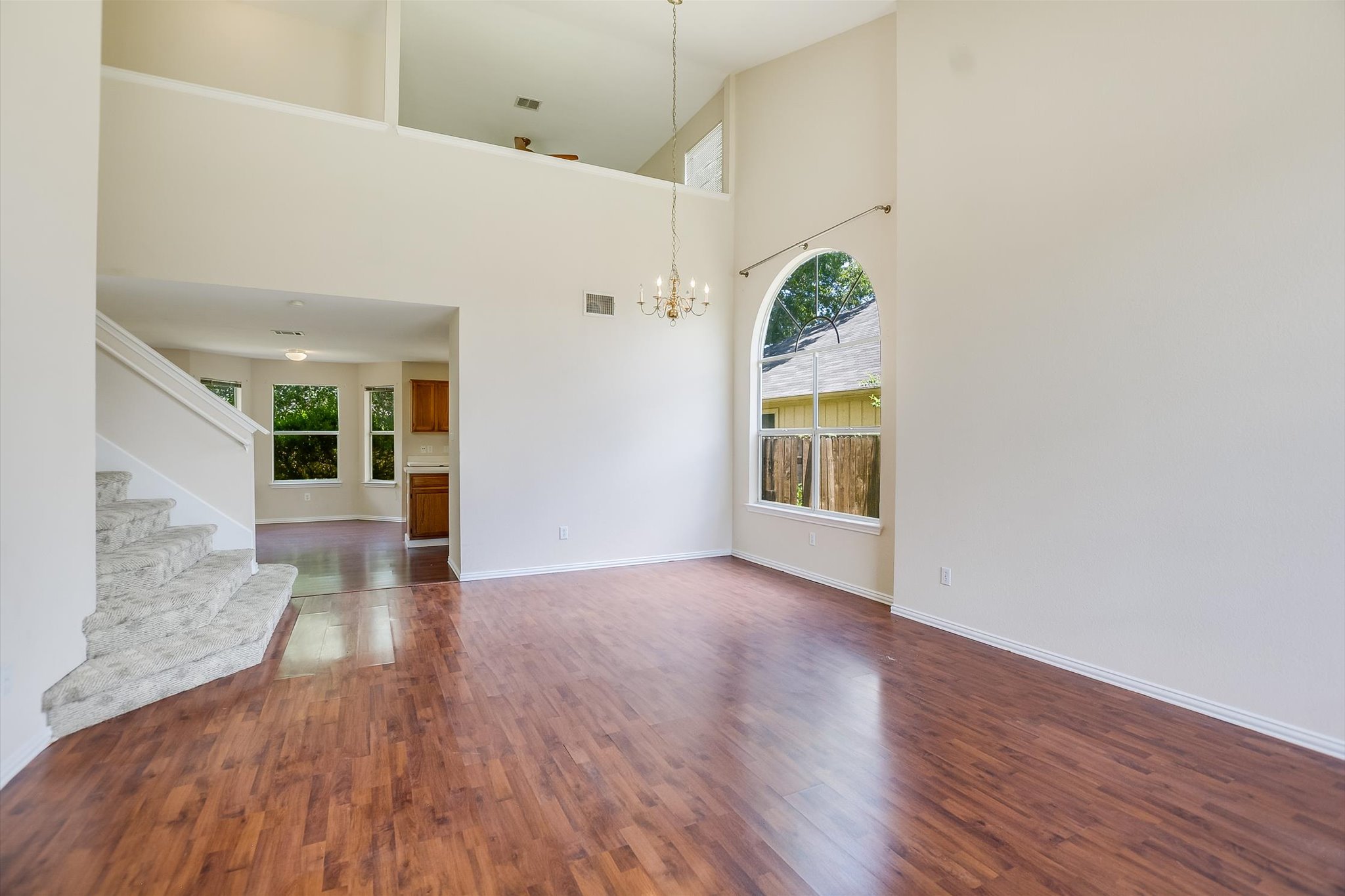 1008 Double File Trail Round Rock, TX 78665 - Photo 4 of 20 Grand arched window illuminates this spacious living area with warm wood flooring and a soaring ceiling.