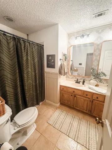 a bathroom with a sink a toilet a mirror a vanity and shower