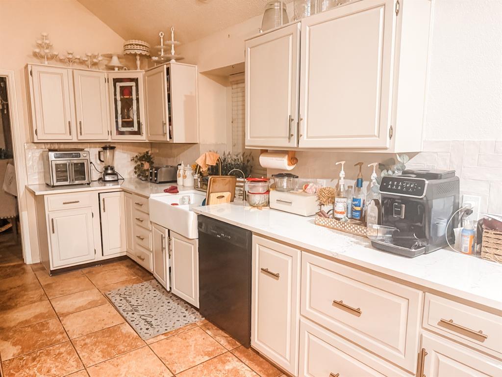6102 Tacoma Street Rowlett, TX 75089 - Photo 9 of 16 a kitchen with a sink dishwasher and white cabinets with wooden floor