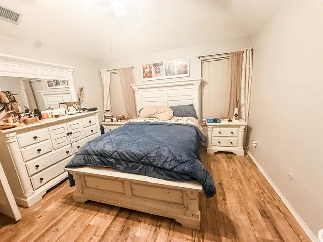 a spacious bedroom with a bed and a cabinets