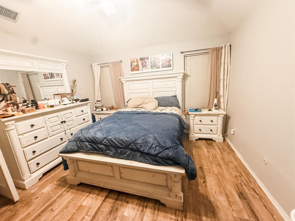 6102 Tacoma Street Rowlett, TX 75089 - Photo 10 of 16 a spacious bedroom with a bed and a cabinets