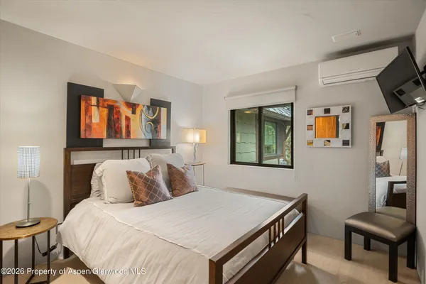 a bedroom with a bed and a flat screen tv