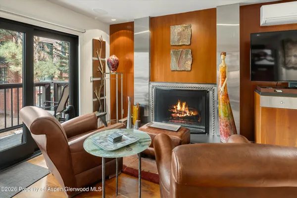 a living room with furniture a fireplace and a large window