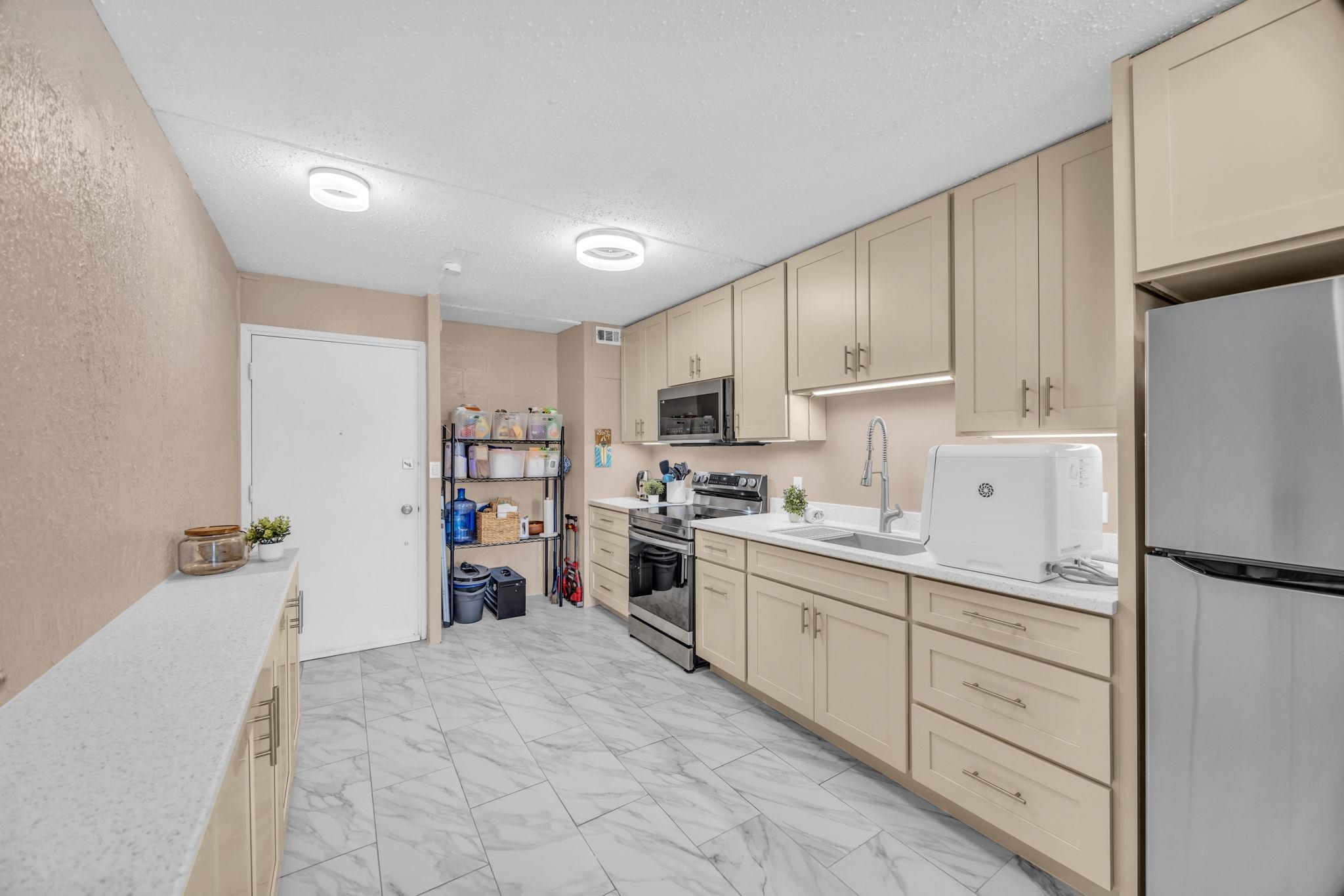 111 Kahului Beach Road, Unit D402 Kahului, HI 96732 - Photo 5 of 27 a kitchen with cabinets and a refrigerator