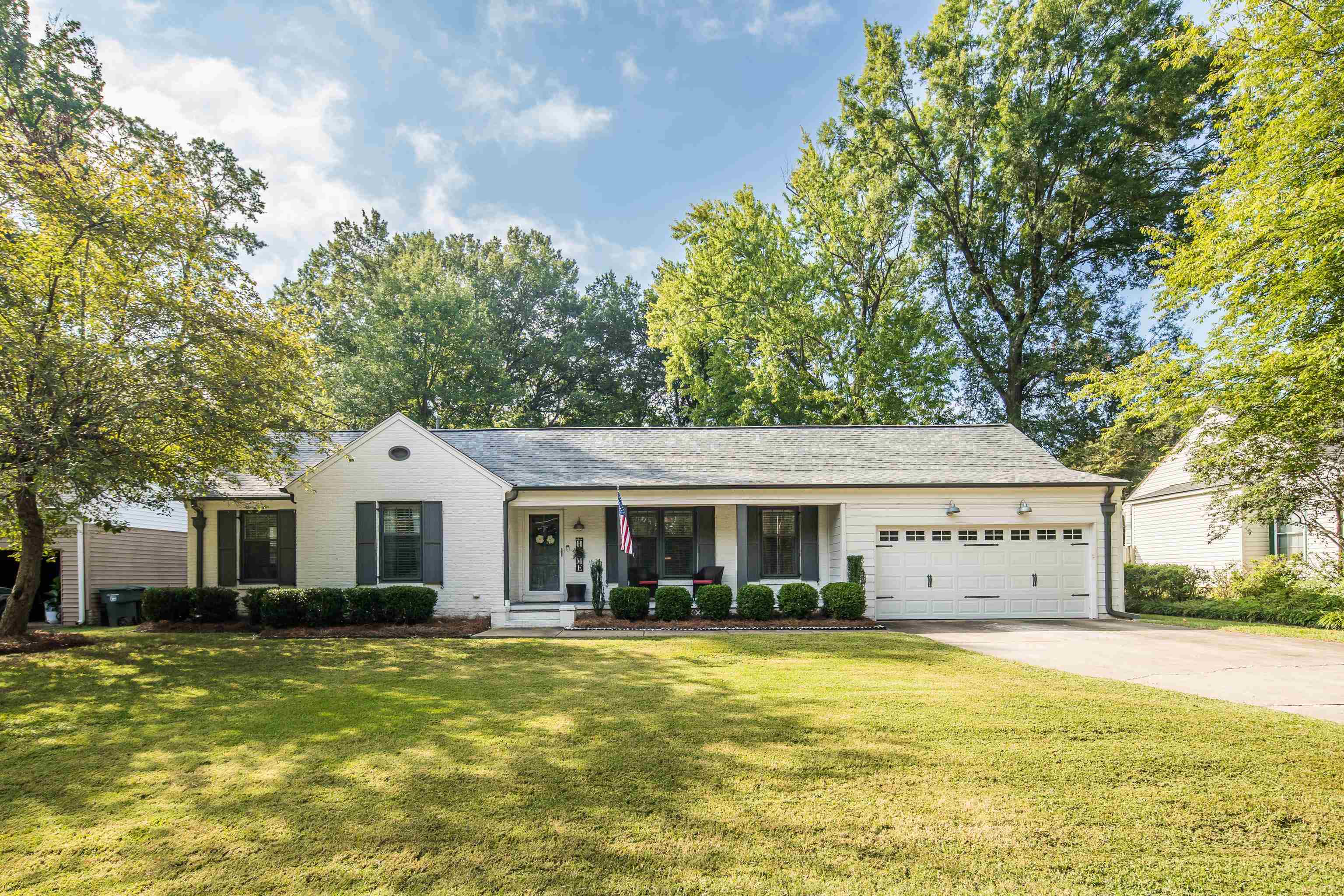 5271 Mason Road Memphis, TN 38120 - Photo 1 of 25 a front view of a house with a garden and trees