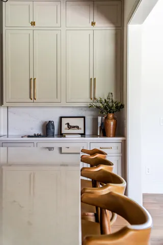 a kitchen with a sink a stove and white cabinets