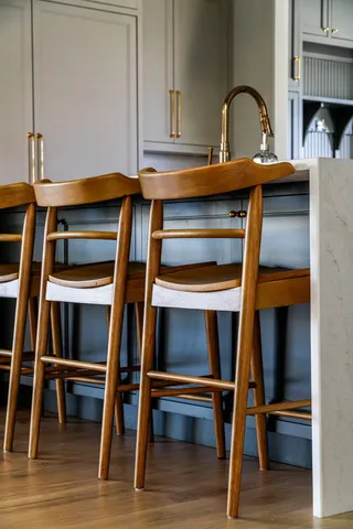 a view of an empty room with wooden floor and furniture