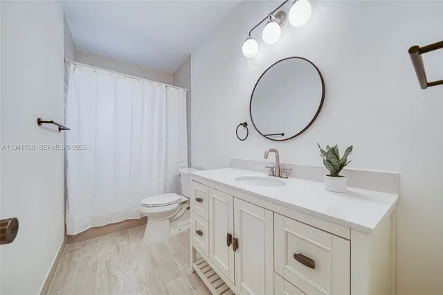 a bathroom with a sink a toilet and a mirror