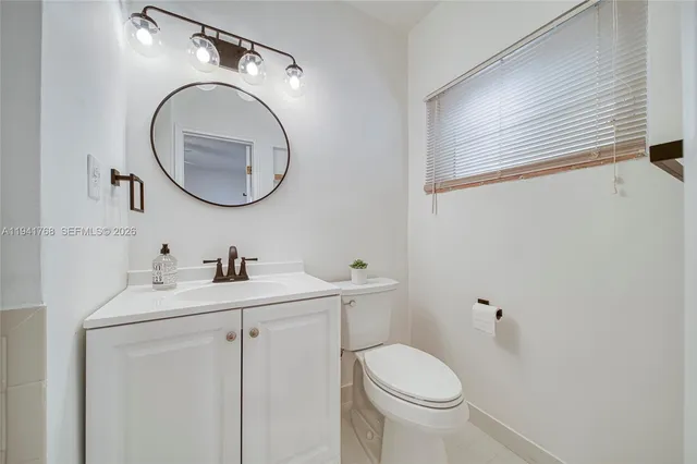 a bathroom with a granite countertop toilet sink and mirror