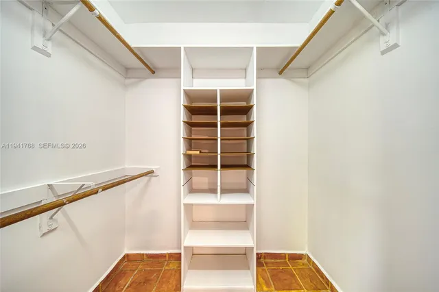 a view of walk in closet with empty racks