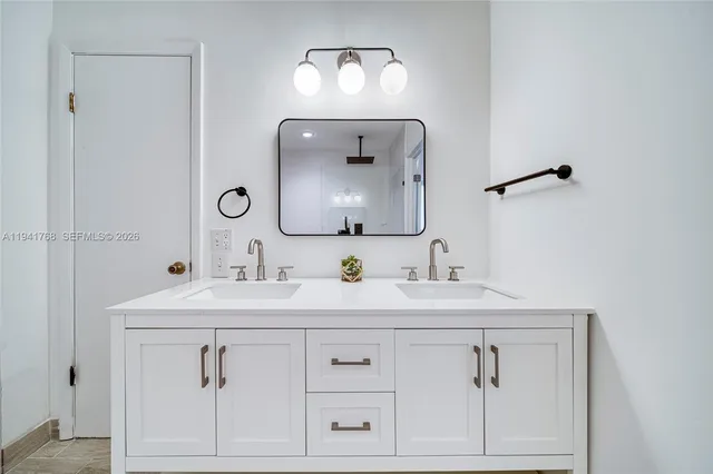 a bathroom with a sink vanity and a mirror