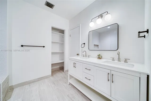 a bathroom with a double vanity sink and mirror