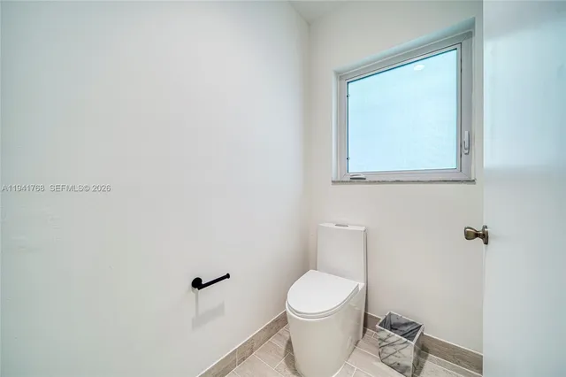 a white toilet sitting next to a white sink and vanity