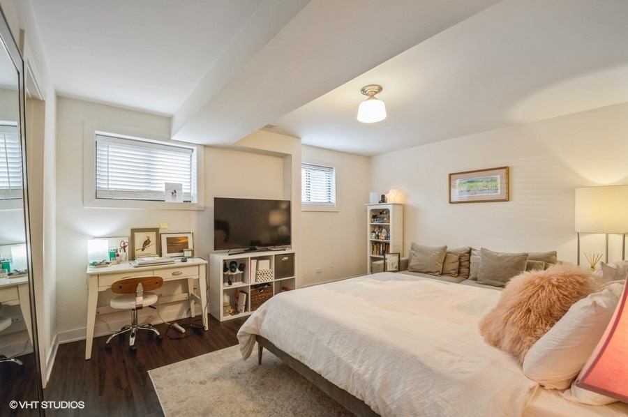 Undisclosed Address Chicago, IL 60657 - Photo 5 of 10 a bedroom with a bed and a flat tv screen on wall