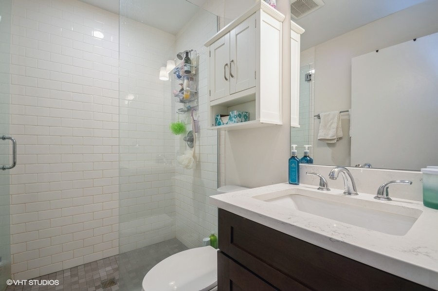 Undisclosed Address Chicago, IL 60657 - Photo 9 of 10 a bathroom with a sink toilet and shower