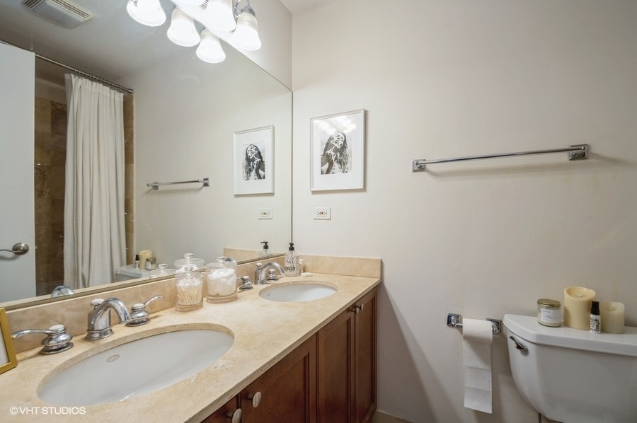 Undisclosed Address Chicago, IL 60657 - Photo 10 of 10 a bathroom with a granite countertop sink a toilet and a mirror
