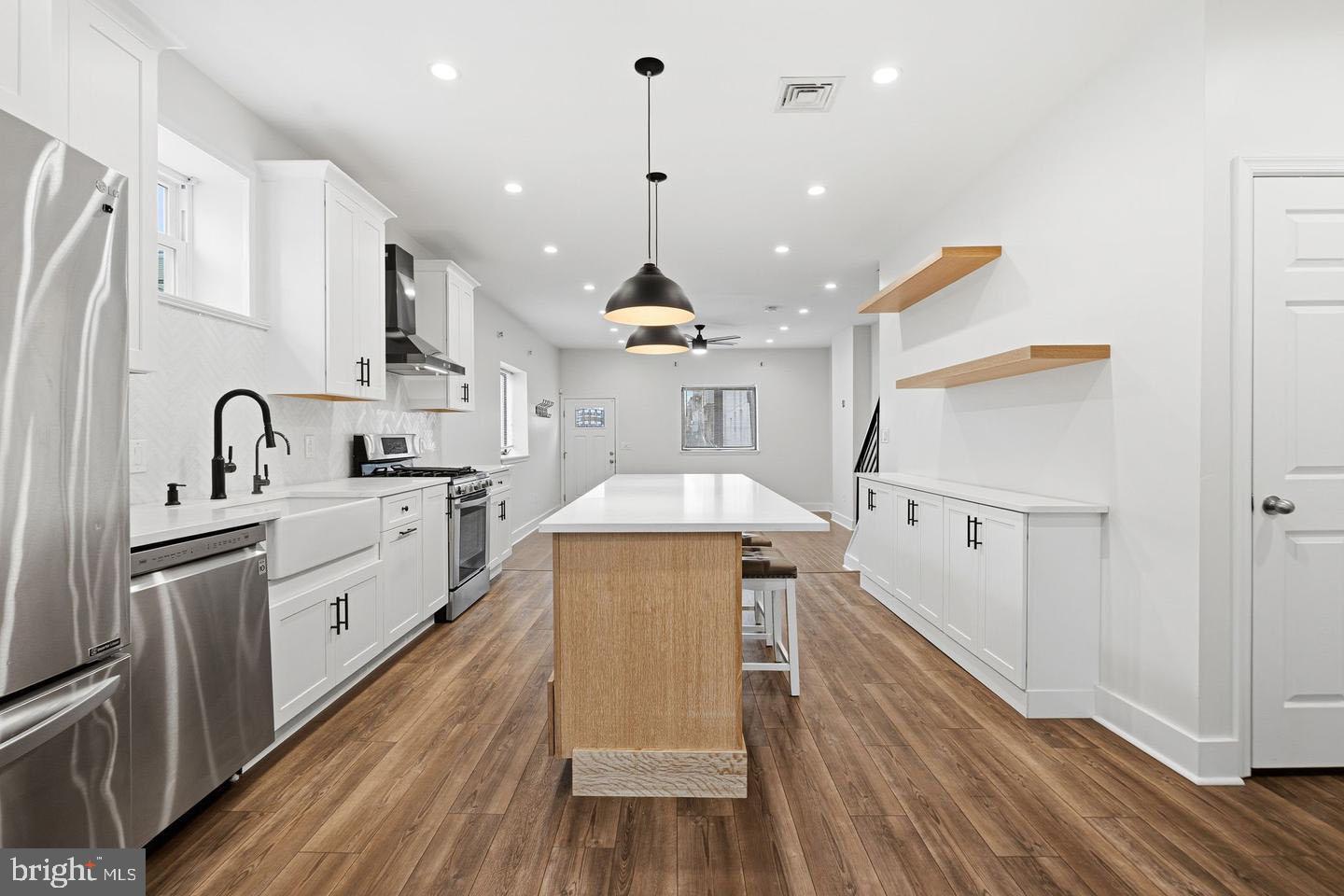 2106 Manton Street Philadelphia, PA 19146 - Photo 5 of 34 a large kitchen with stainless steel appliances a stove a sink dishwasher and a refrigerator with wooden floor