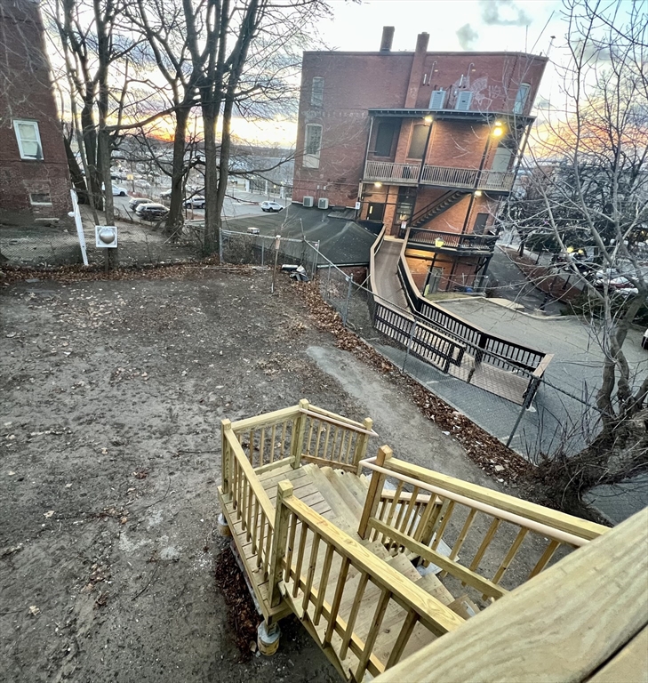 68 Springfield Street Chicopee, MA 01013 - Photo 34 of 41 a view of a roof deck with wooden fence and a bench