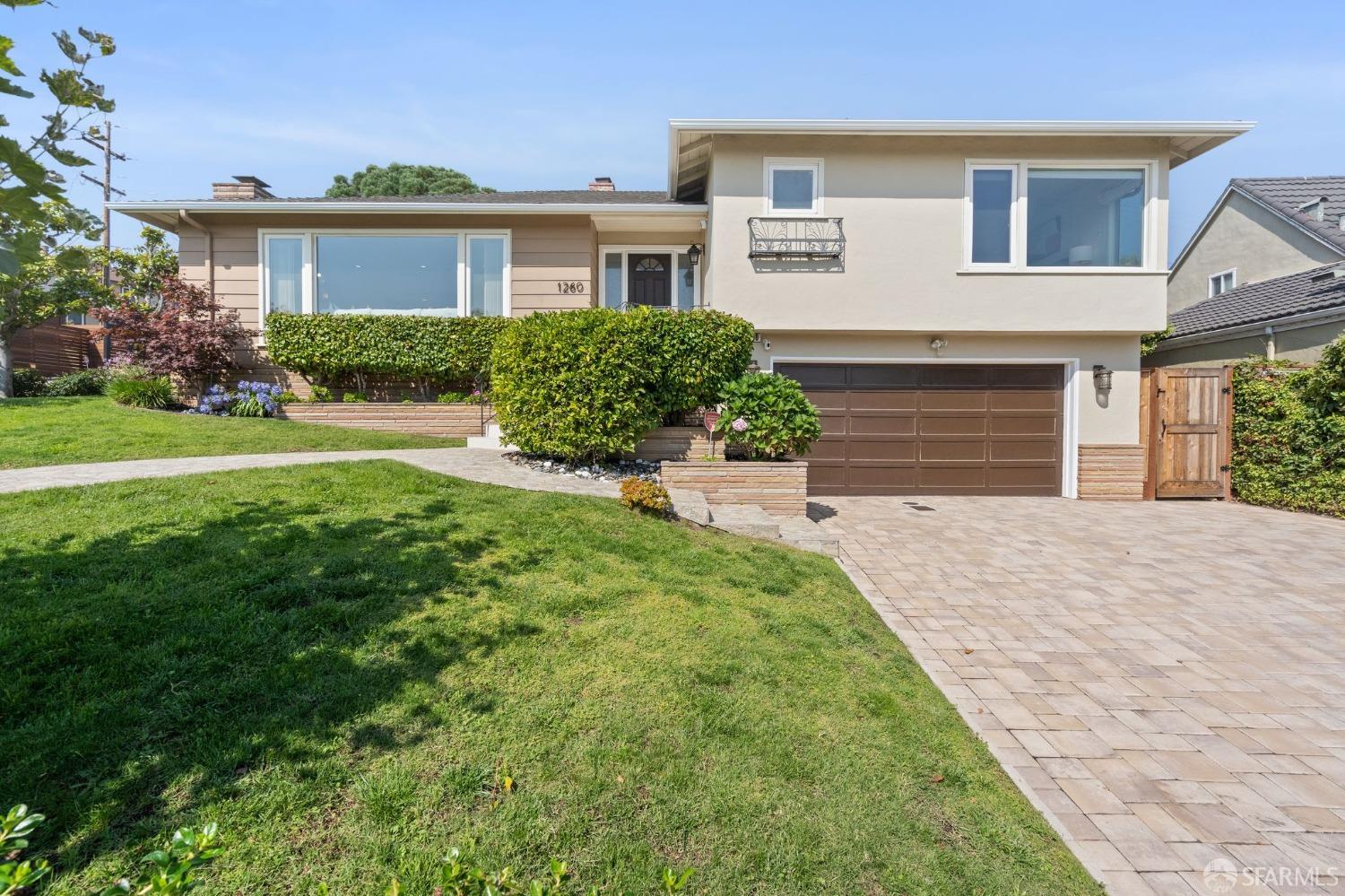 a front view of a house with a yard and trees