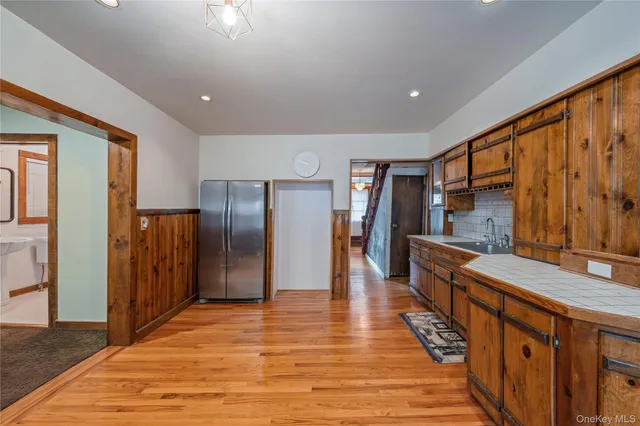 a hallway with wooden floor a fireplace and windows