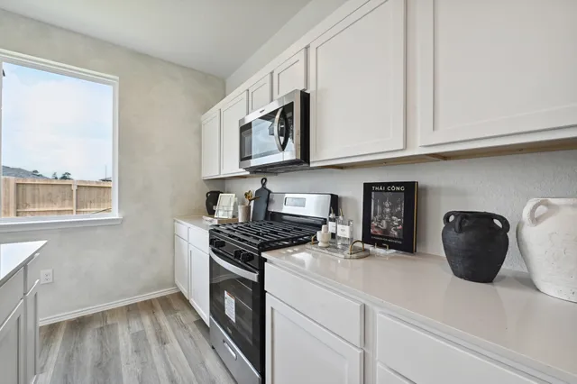 a kitchen with stainless steel appliances granite countertop a stove a sink and a microwave