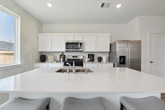 a kitchen with kitchen island a refrigerator stove and microwave