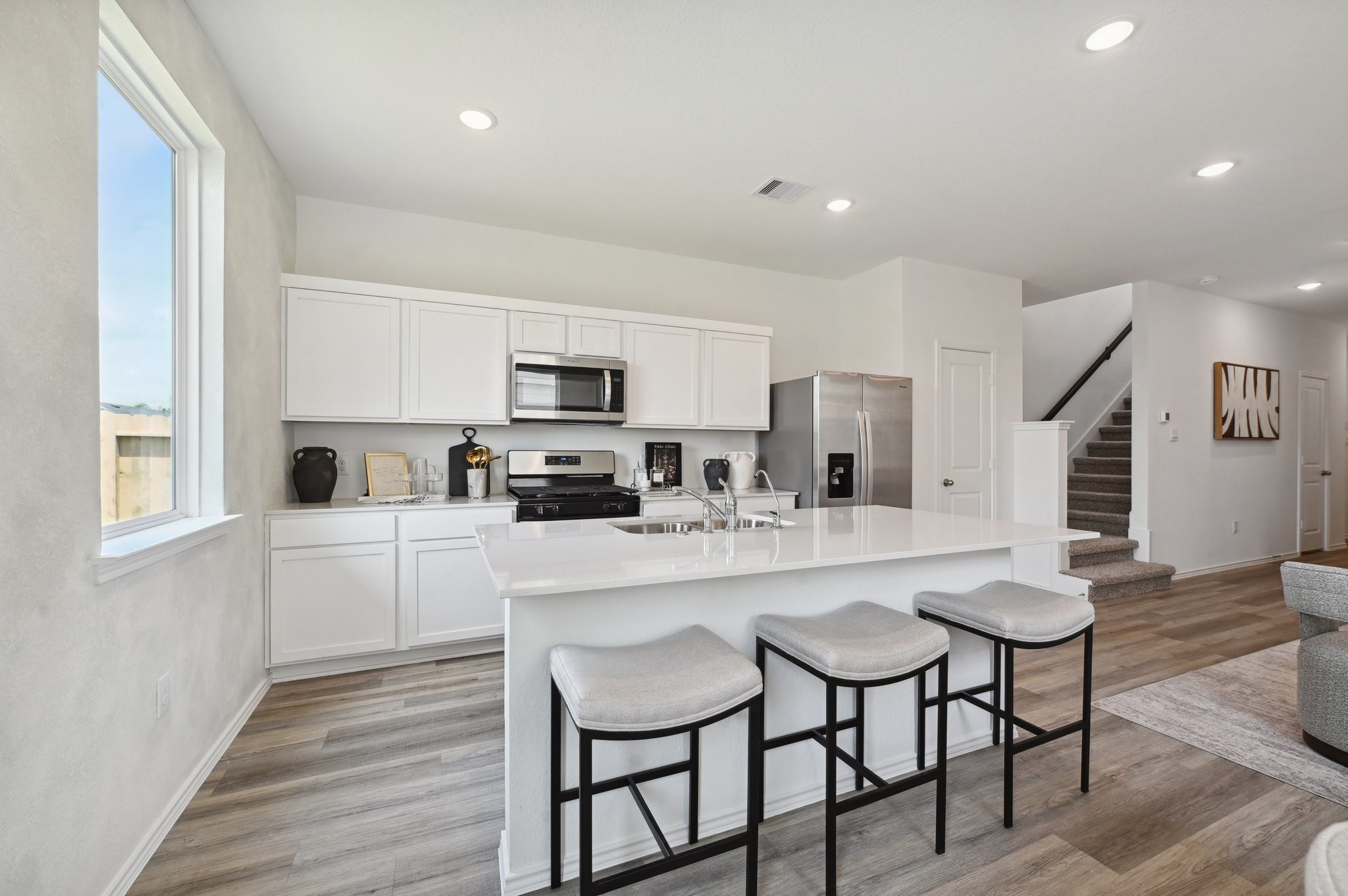 16911 Vinters Way Houston, TX 77090 - Photo 15 of 26 a kitchen with white cabinets and stainless steel appliances