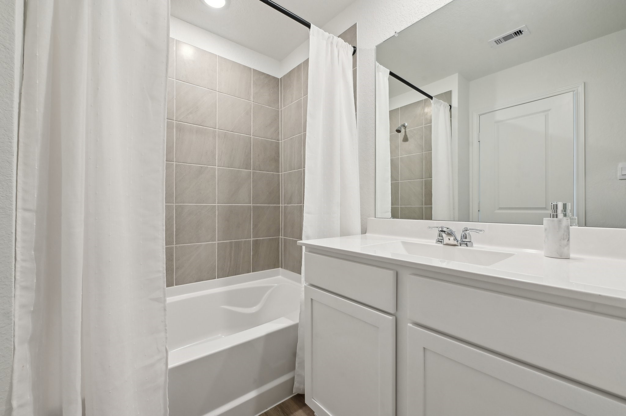 16911 Vinters Way Houston, TX 77090 - Photo 17 of 26 a bathroom with a tub sink and mirror