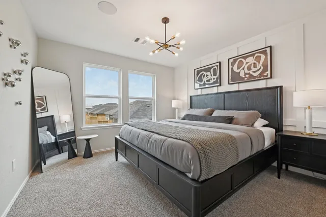 a bedroom with a bed painting on wall and a large window