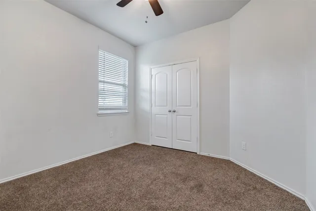 an empty room with windows and closet
