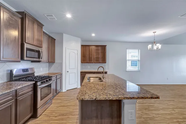 a kitchen with sink cabinets and wooden floor