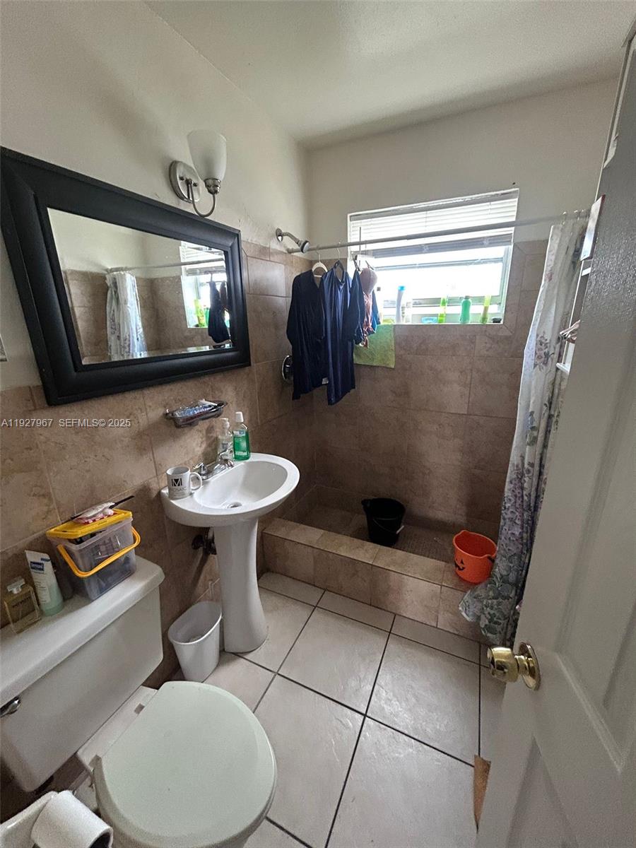6124 Pembroke Road Miramar, FL 33023 - Photo 19 of 20 a bathroom with a toilet sink and mirror