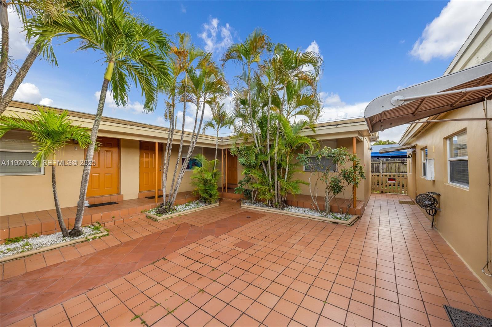 6124 Pembroke Road Miramar, FL 33023 - Photo 4 of 20 a view of a brick house with many windows next to a road
