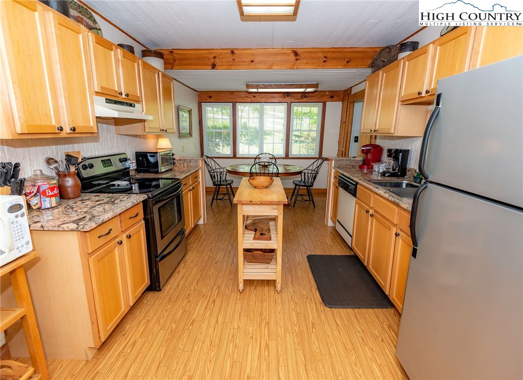 2280 Garvey Bridge Road Crumpler, NC 28617 - Photo 26 of 45 a kitchen with stainless steel appliances granite countertop a stove a sink dishwasher and a refrigerator with wooden floor