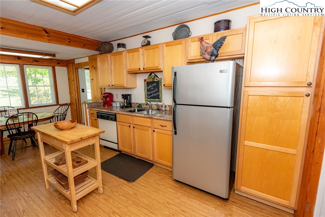 2280 Garvey Bridge Road Crumpler, NC 28617 - Photo 28 of 45 a kitchen with a refrigerator a table and chairs
