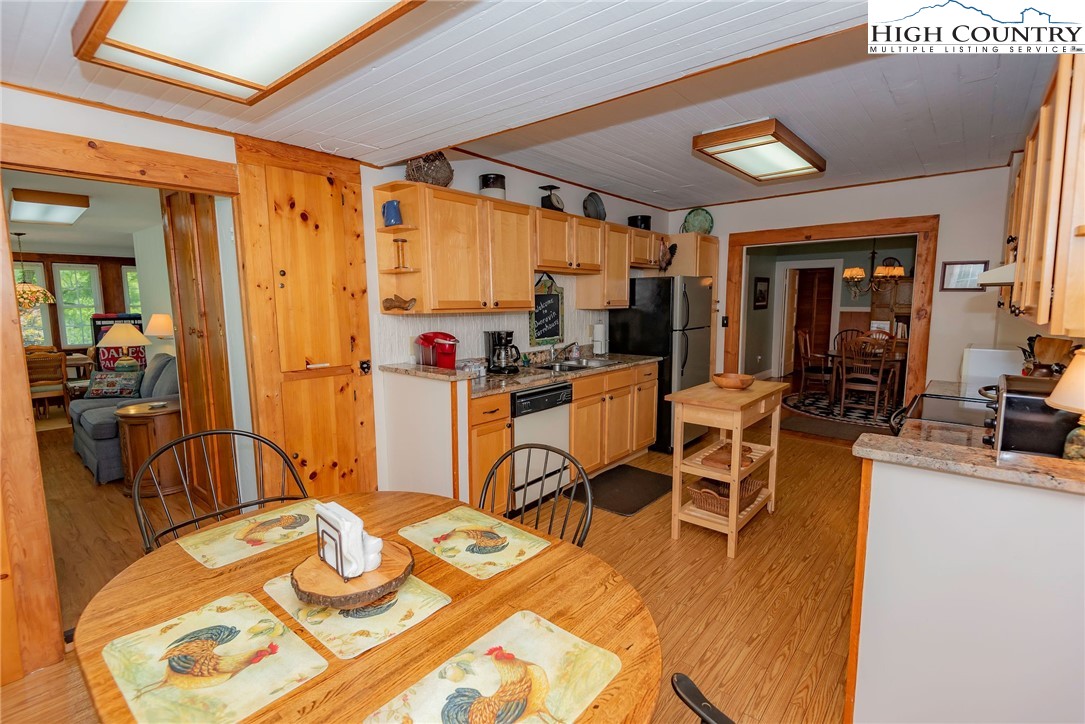 2280 Garvey Bridge Road Crumpler, NC 28617 - Photo 30 of 45 a view of a dining room with furniture a kitchen and chandelier