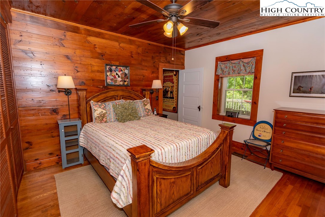 2280 Garvey Bridge Road Crumpler, NC 28617 - Photo 34 of 45 a bedroom with a bed and a chandelier