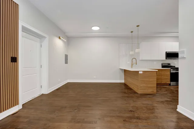 a view of a kitchen with kitchen island a sink wooden floor and glass door