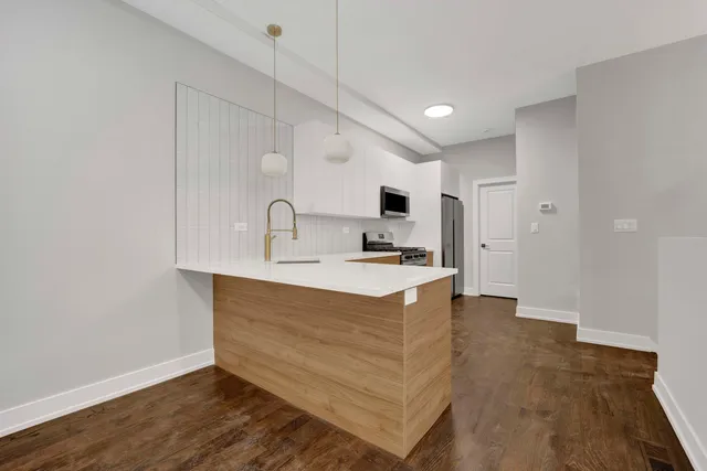 a kitchen with kitchen island a sink stainless steel appliances and cabinets
