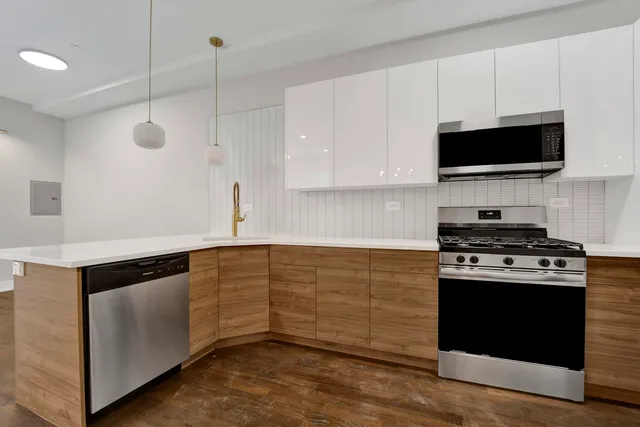 a kitchen with stainless steel appliances a stove a microwave and white cabinets