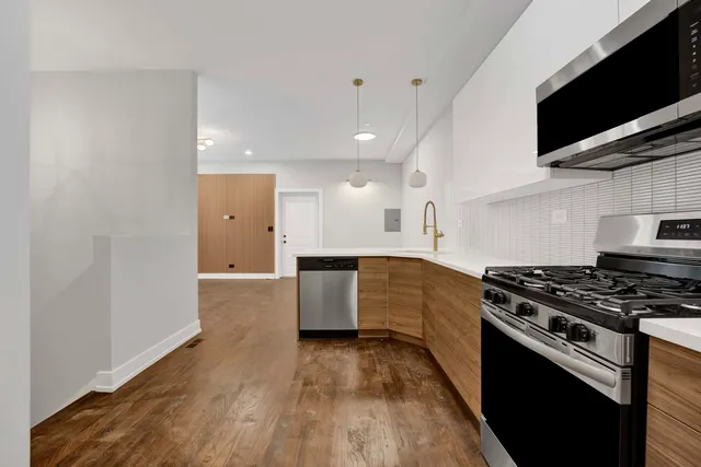 a kitchen with stainless steel appliances granite countertop a stove a sink and a microwave