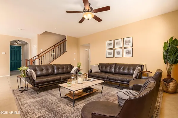 a living room with furniture ceiling fan and a rug