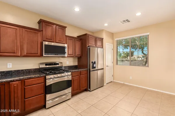 a kitchen with stainless steel appliances granite countertop a stove a sink and a microwave