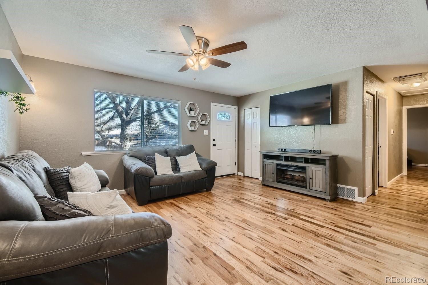 8207 High Street Denver, CO 80229 - Photo 2 of 11 a living room with furniture and a flat screen tv