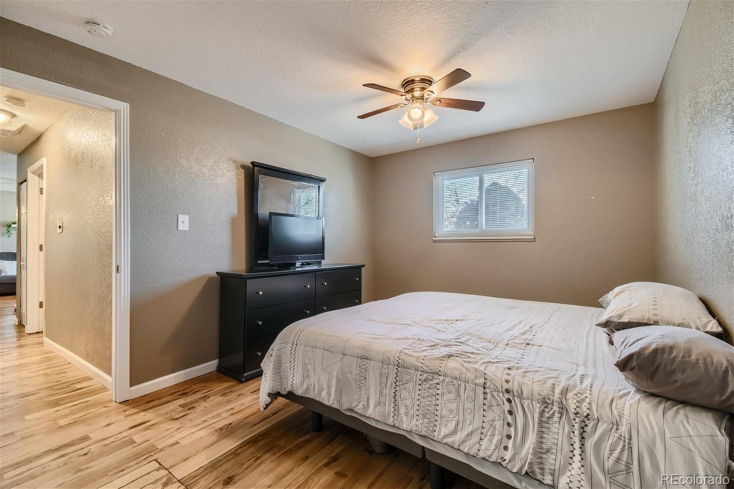 8207 High Street Denver, CO 80229 - Photo 5 of 11 a bedroom with a bed and a chandelier