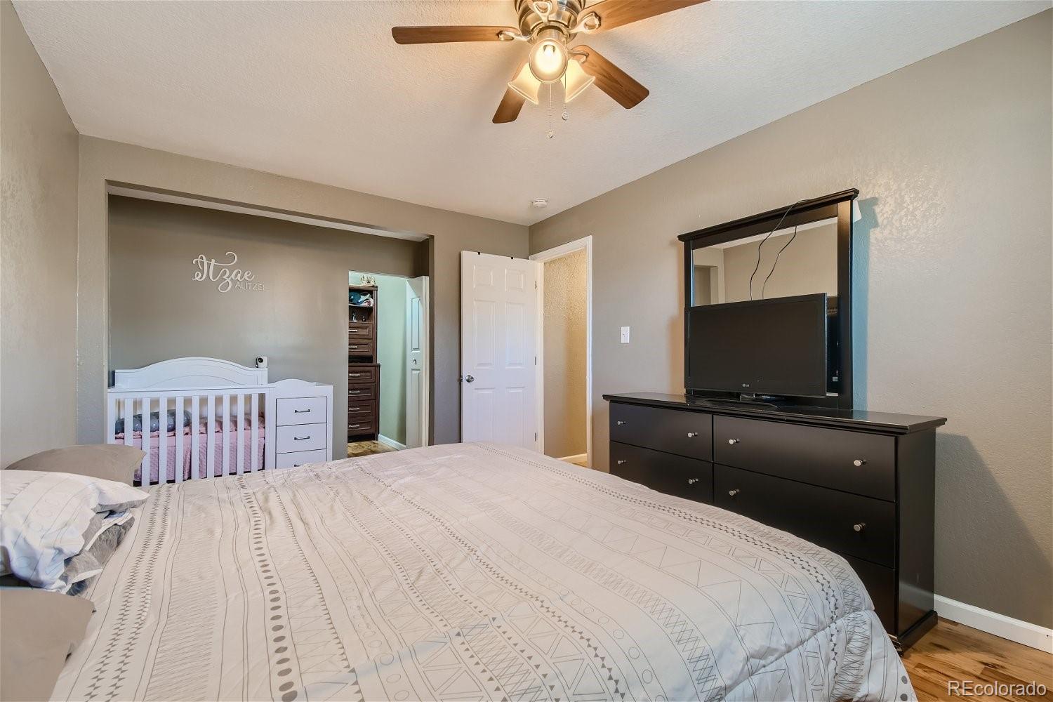 8207 High Street Denver, CO 80229 - Photo 6 of 11 a bedroom with a bed and a flat tv screen on dresser