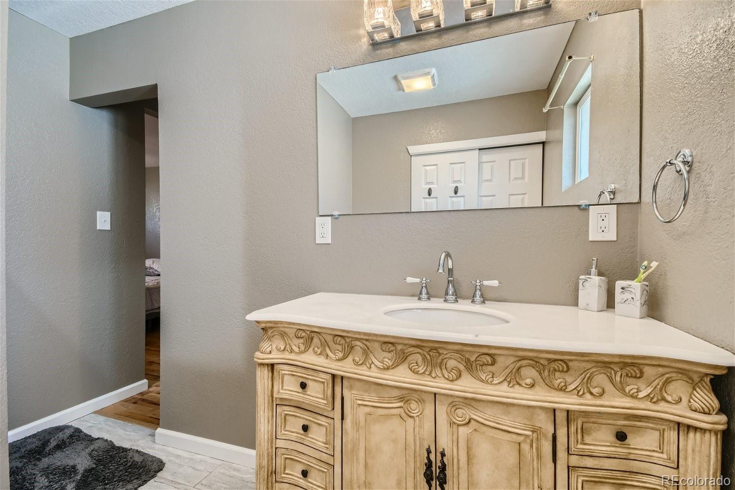 8207 High Street Denver, CO 80229 - Photo 8 of 11 a bathroom with a sink vanity and a mirror