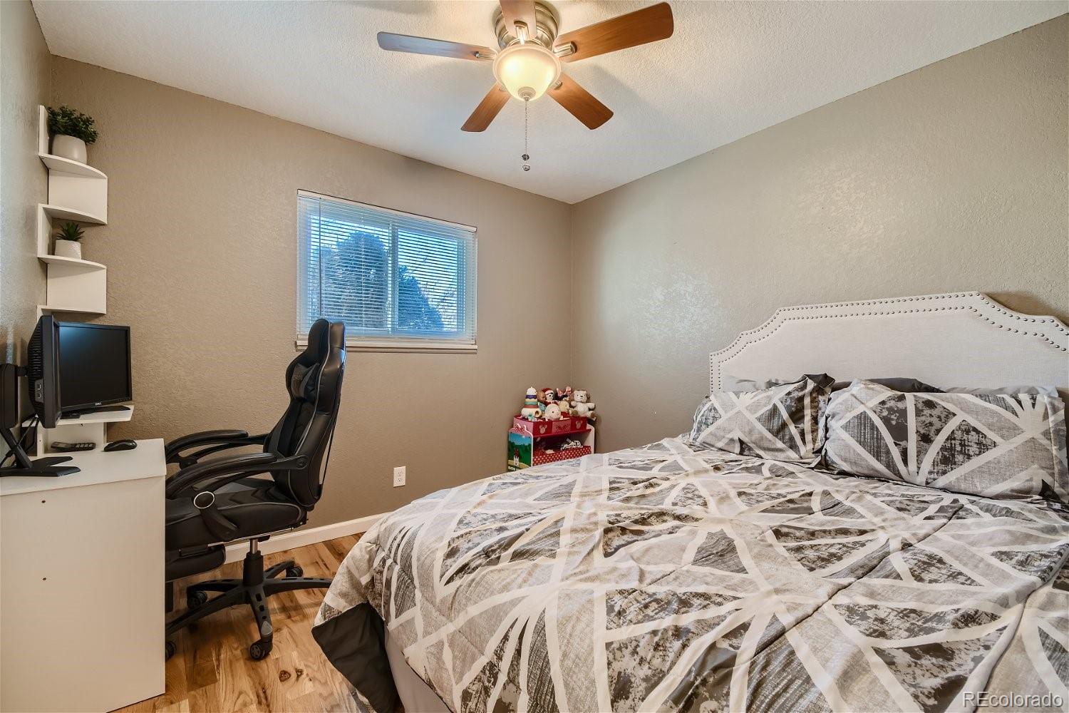 8207 High Street Denver, CO 80229 - Photo 9 of 11 a bedroom with a bed and a chandelier